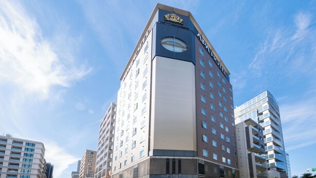 A modern hotel with a prominent 'HOTEL' sign, multiple floors, and a mix of glass and concrete exterior. - APA Hotel Nihonbashi Hamacho Ekiminami (Tokyo)
