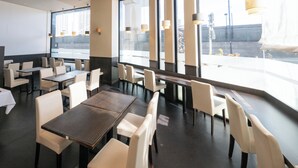 A modern dining area with tables and chairs, large windows, and pendant lighting. - APA Hotel Nihonbashi Hamacho Ekiminami (Tokyo)