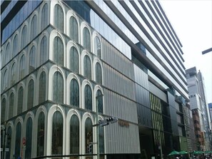 Ein modernes Gebäude mit Bogenfenstern und einer Fassade aus Glas und Metall.