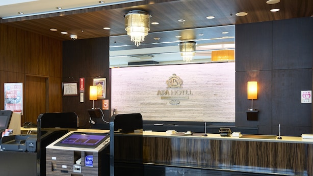 A hotel reception area with a digital check-in kiosk, a reception desk, and a chandelier. - APA Hotel Toyama Ekimae Minami (Toyama)