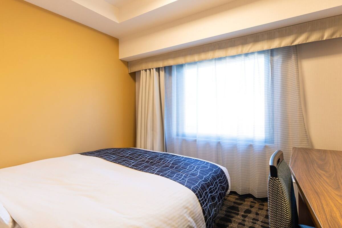 Escritorio, cortinas blackout y tabla de planchar con plancha