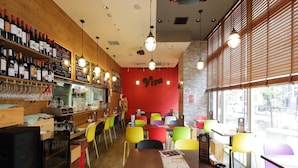 A restaurant interior with wooden walls, a red wall with 'Viva' written on it, and colorful chairs. - APA Hotel Toyama Ekimae Minami (Toyama)