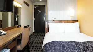 A hotel room with a bed, a desk, a chair, a mirror, and a door. - APA Hotel Toyama Ekimae Minami (Toyama)