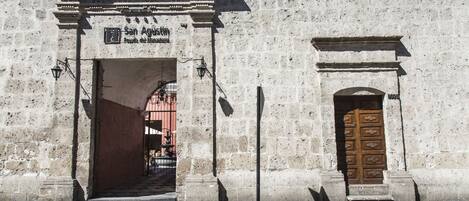 Un edificio histórico de piedra con una puerta de madera grande y un arco de entrada.