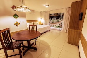 Deluxe Suite | Living area | 40-inch flat-screen TV with cable channels, TV