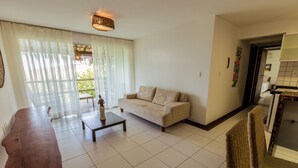 Amplia sala de estar con sofá, una mesa de centro y una mesa de comedor.