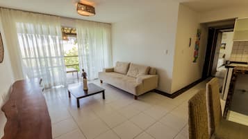 Quarto quádruplo, 2 camas Queen, sacada | Sala de estar | TV de tela plana 40 polegadas com canais a cabo, TV