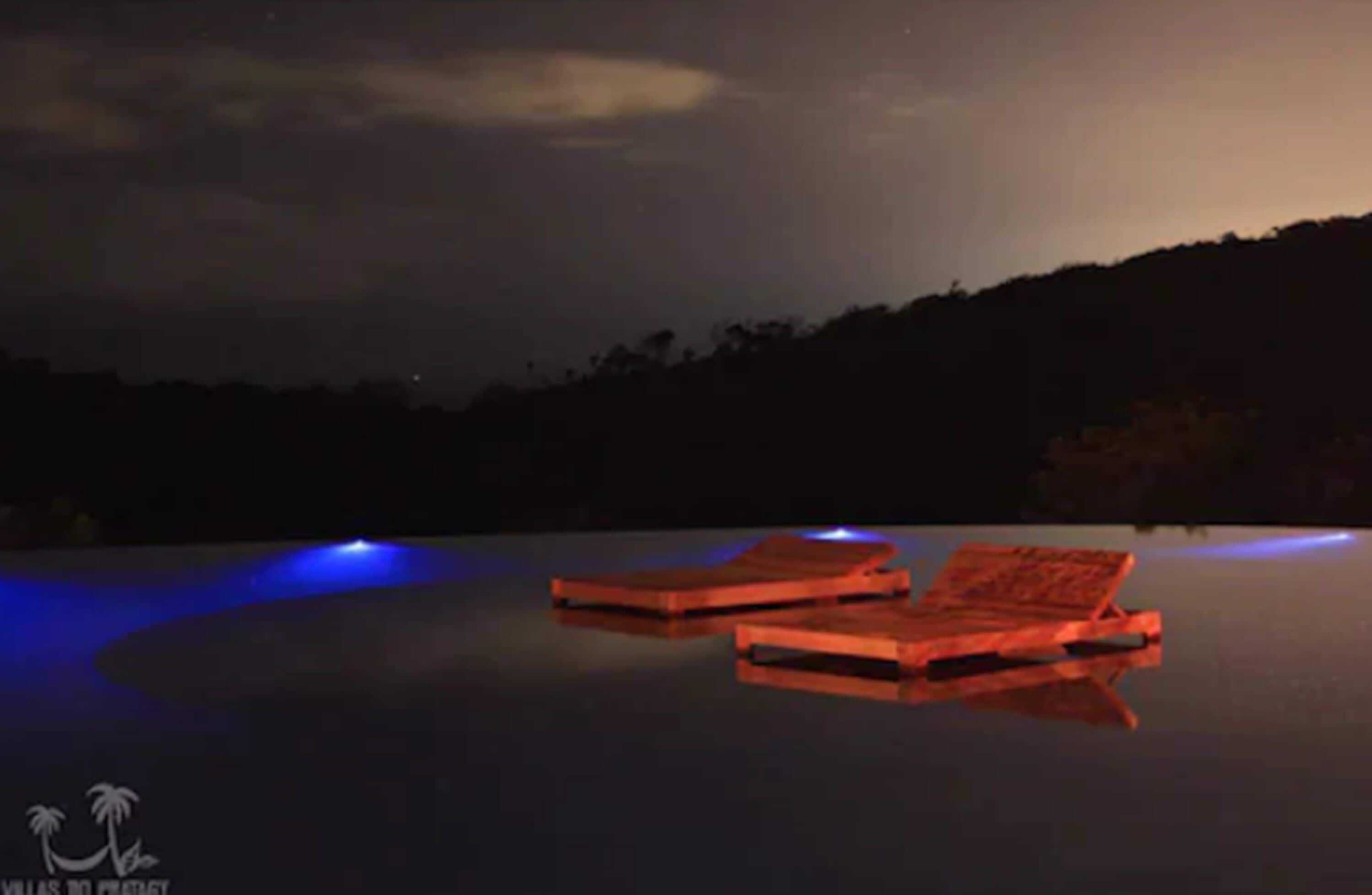 A pool with two floating platforms and a night sky.