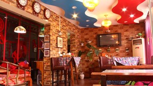 A restaurant with brick walls, wooden furniture, and a modern ceiling design. - The Classic Courtyard (Beijing)