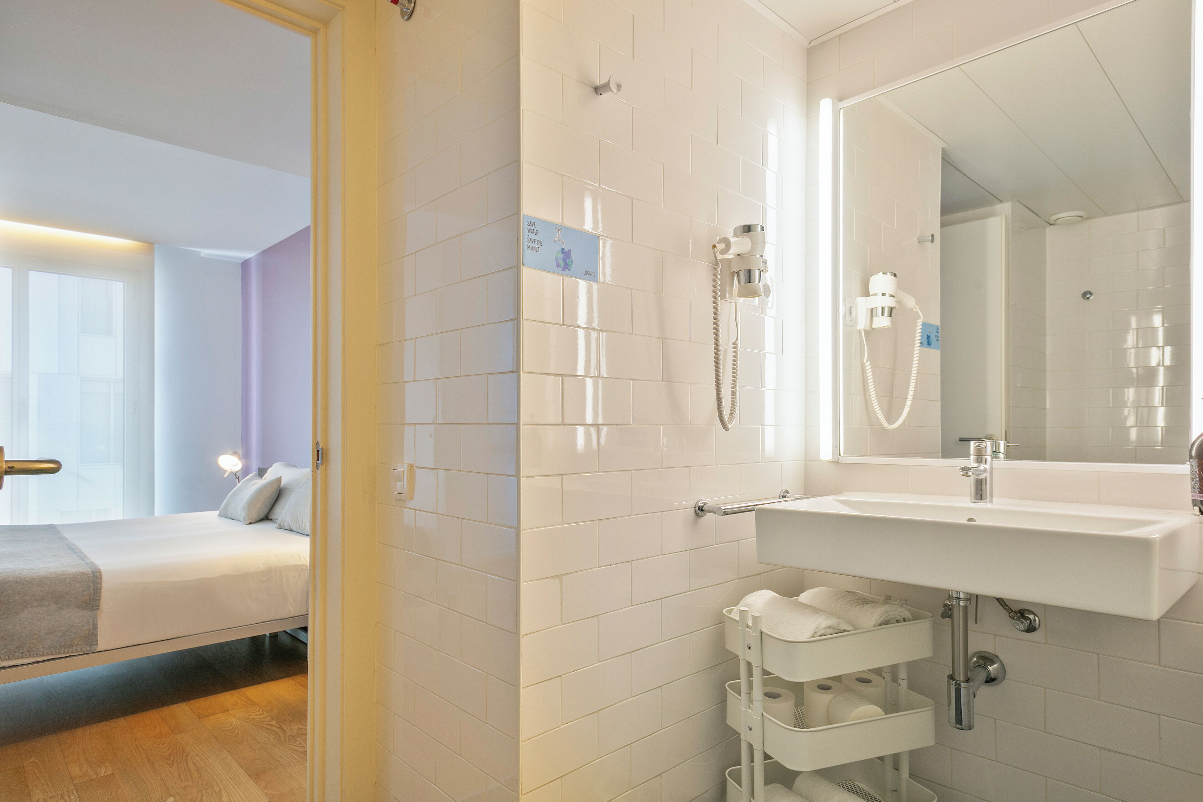 A modern bathroom with a white sink, mirror, and shower.