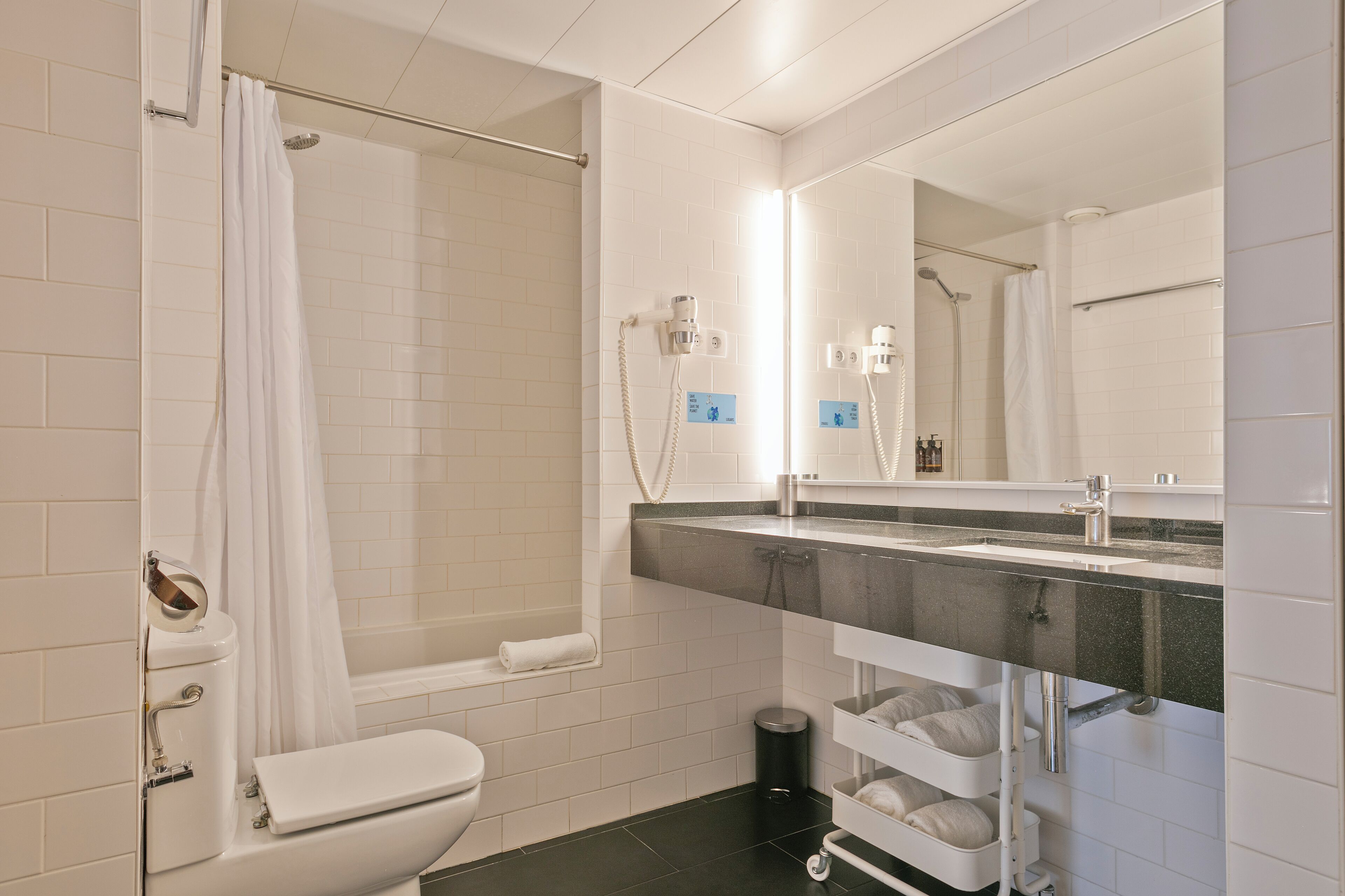 A modern bathroom with a shower, toilet, and sink.