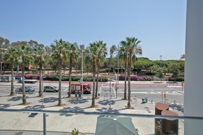 Vista de calle con palmeras, un camión de bomberos rojo y un paso de peatones.