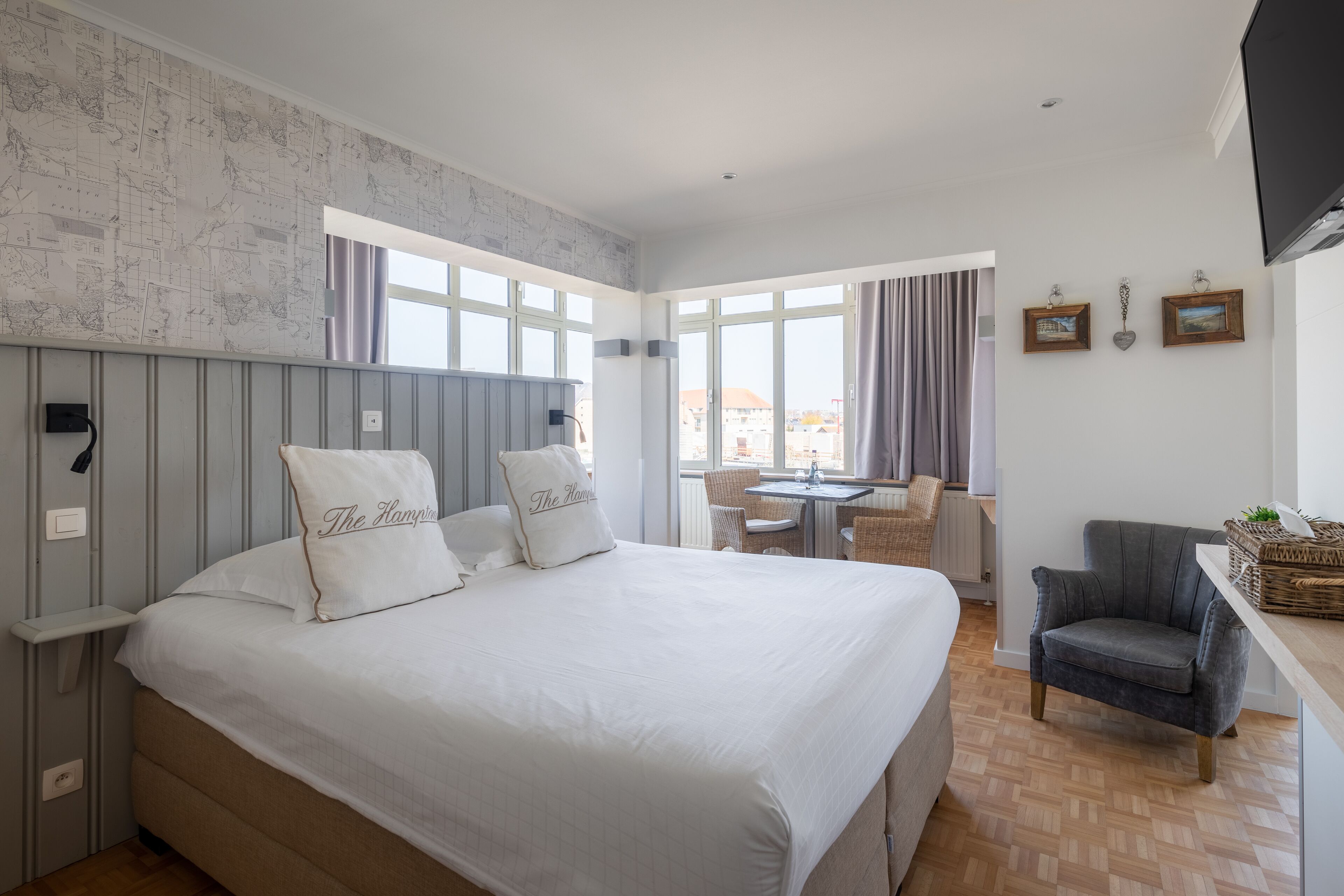 A bedroom with a large bed, a desk, and a chair.