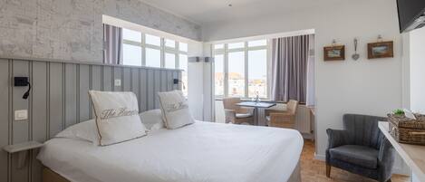 Un dormitorio con una cama grande, un escritorio y una silla.