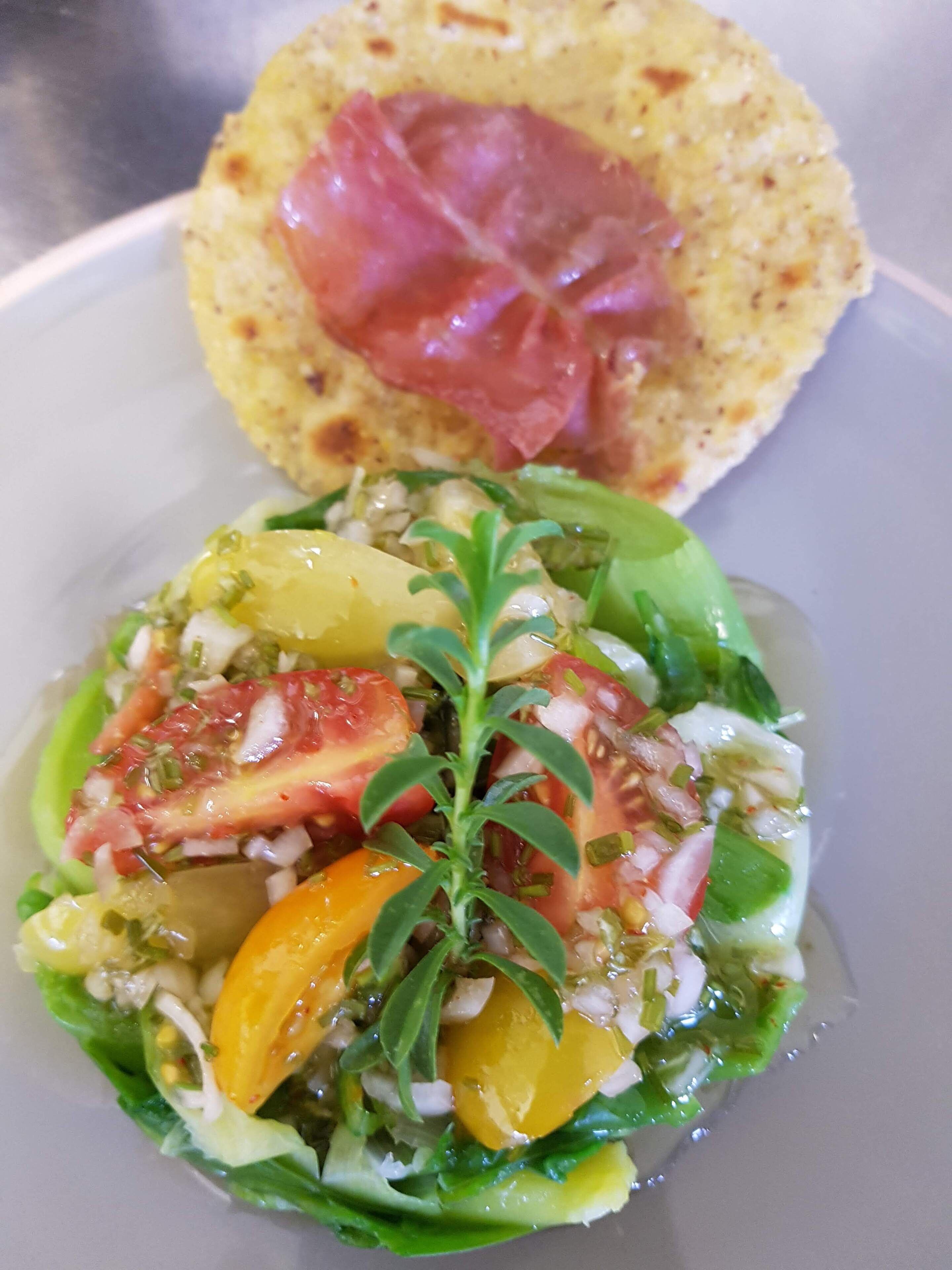 A dish with a variety of vegetables and a piece of meat on a plate.