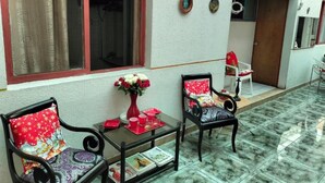 A room with two chairs, a small table, and a window with curtains. - Hotel Angamos (Santiago)