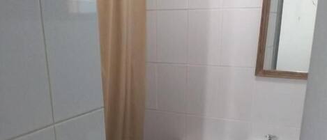 A small bathroom with a toilet, sink, and a mirror.
