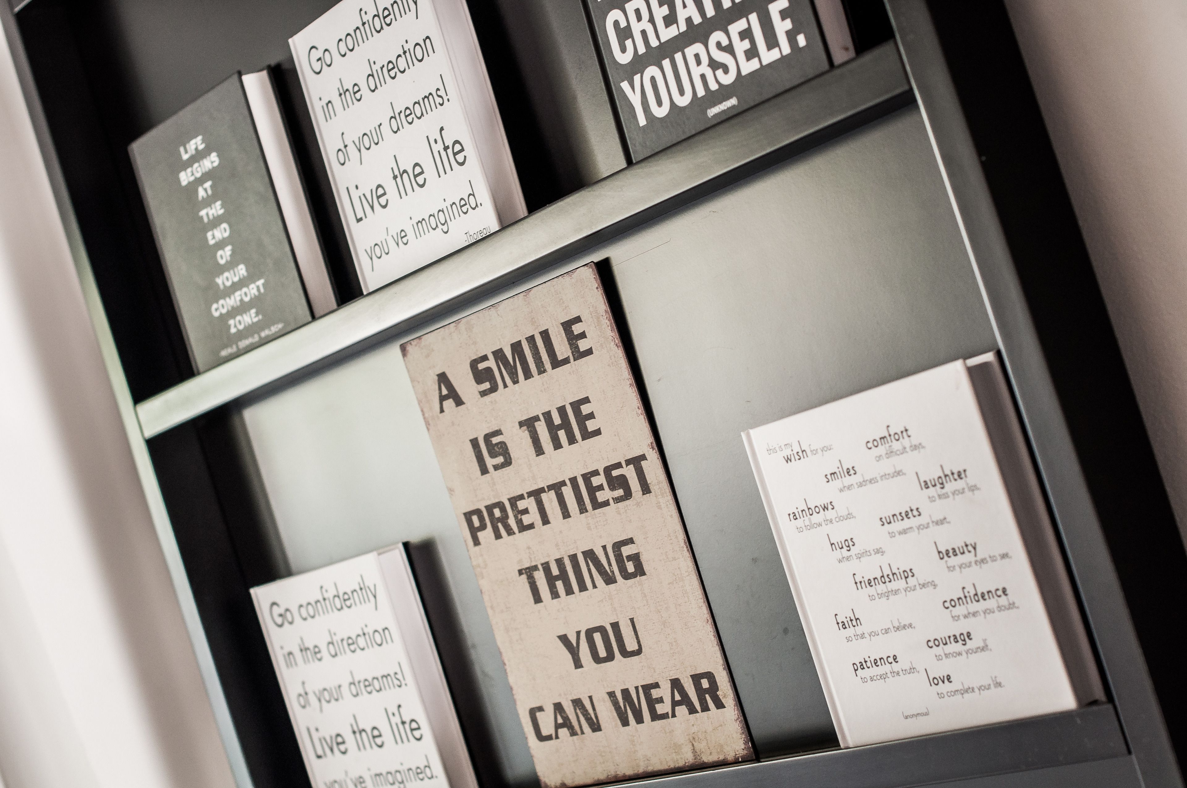 Un conjunto de tarjetas con citas inspiradoras expuestas en una estantería.