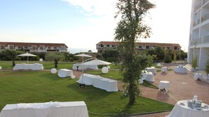 A courtyard with tables and chairs set up for an event, surrounded by buildings and greenery. - San Domenico Family Hotel (Scalea)