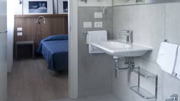 Un baño moderno con lavabo, bidé y espejo de tocador.