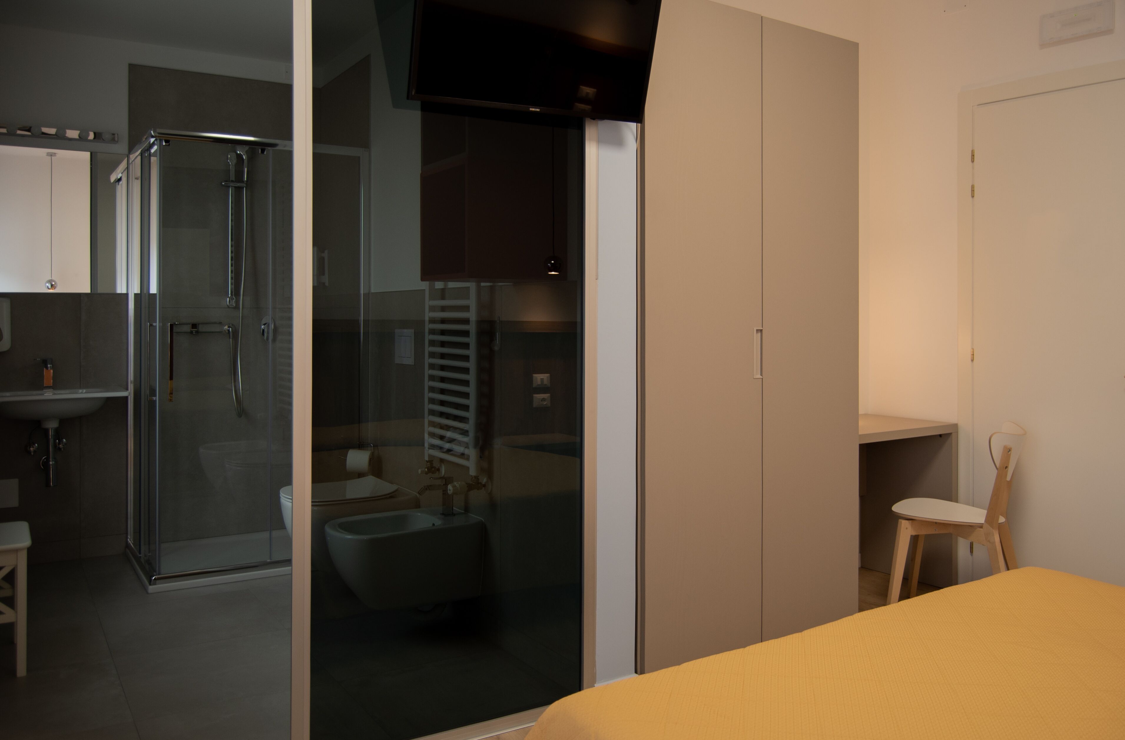 A modern bathroom with a glass shower enclosure, a toilet, and a sink.