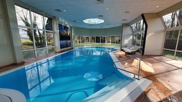 Relax by the pool with a view of the surrounding landscape through large windows.