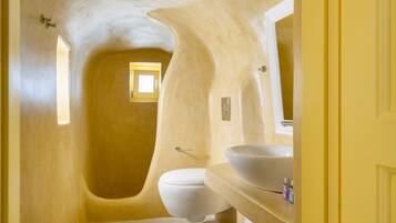 Ein Badezimmer mit einem außergewöhnlichen, gewölbten Design, einer Badewanne, einer Toilette und einem Waschbecken mit Spiegel.
