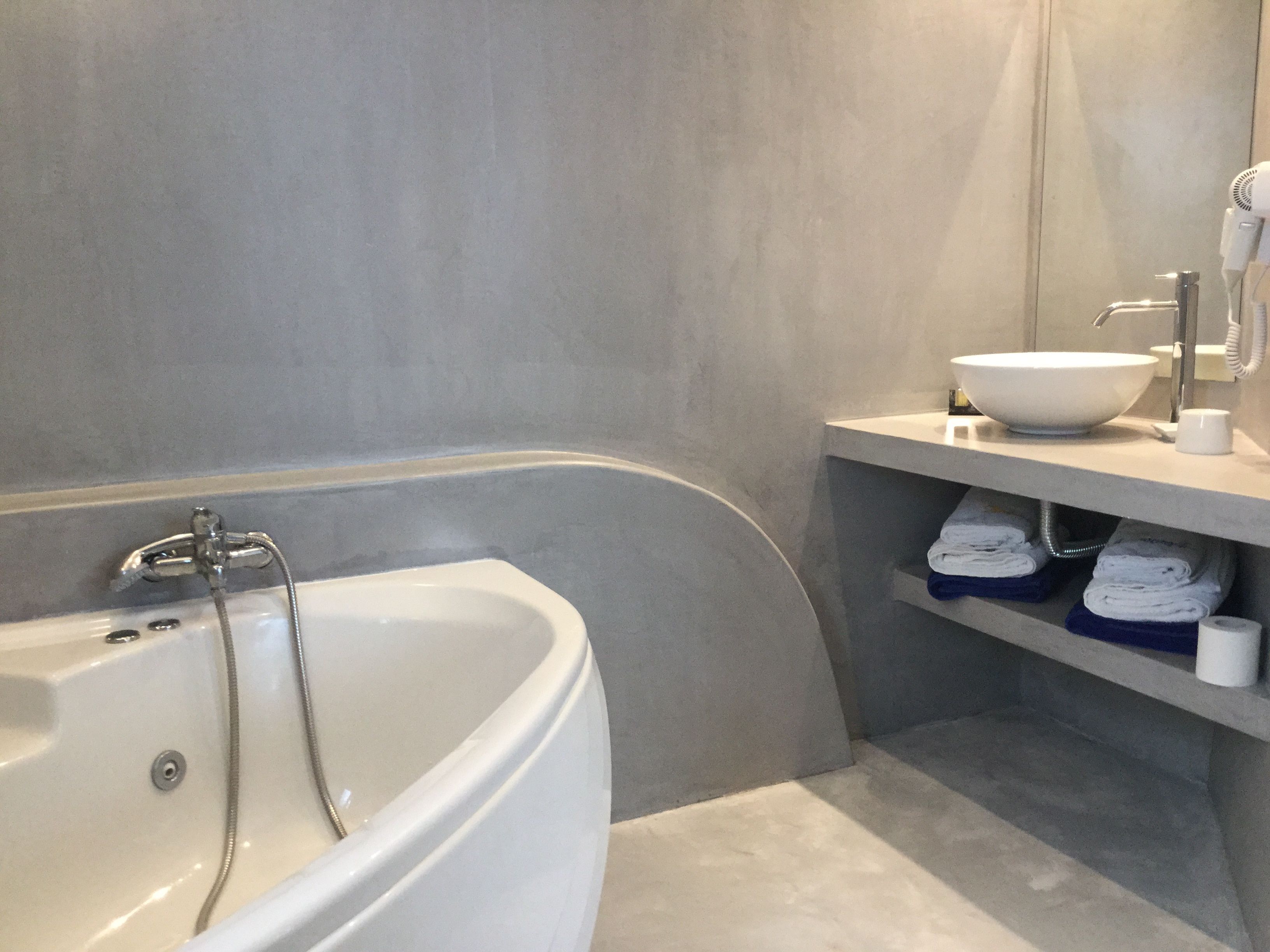 A modern bathroom with a freestanding bathtub, a white sink, and a towel rack with folded towels.