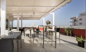 An outdoor patio with tables and chairs, a covered area, and potted plants. - Hotel 33 Baroni (Gallipoli)