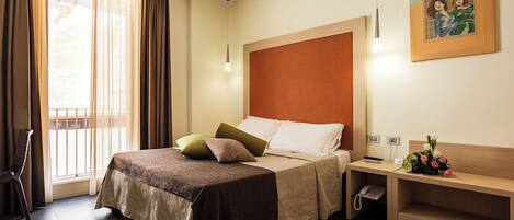 Una habitación de hotel con cama, mesita de noche y un cuadro en la pared.