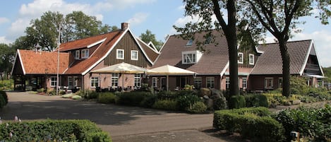 Een klassiek gebouw met een bakstenen gevel, meerdere ramen en een schuin dak.