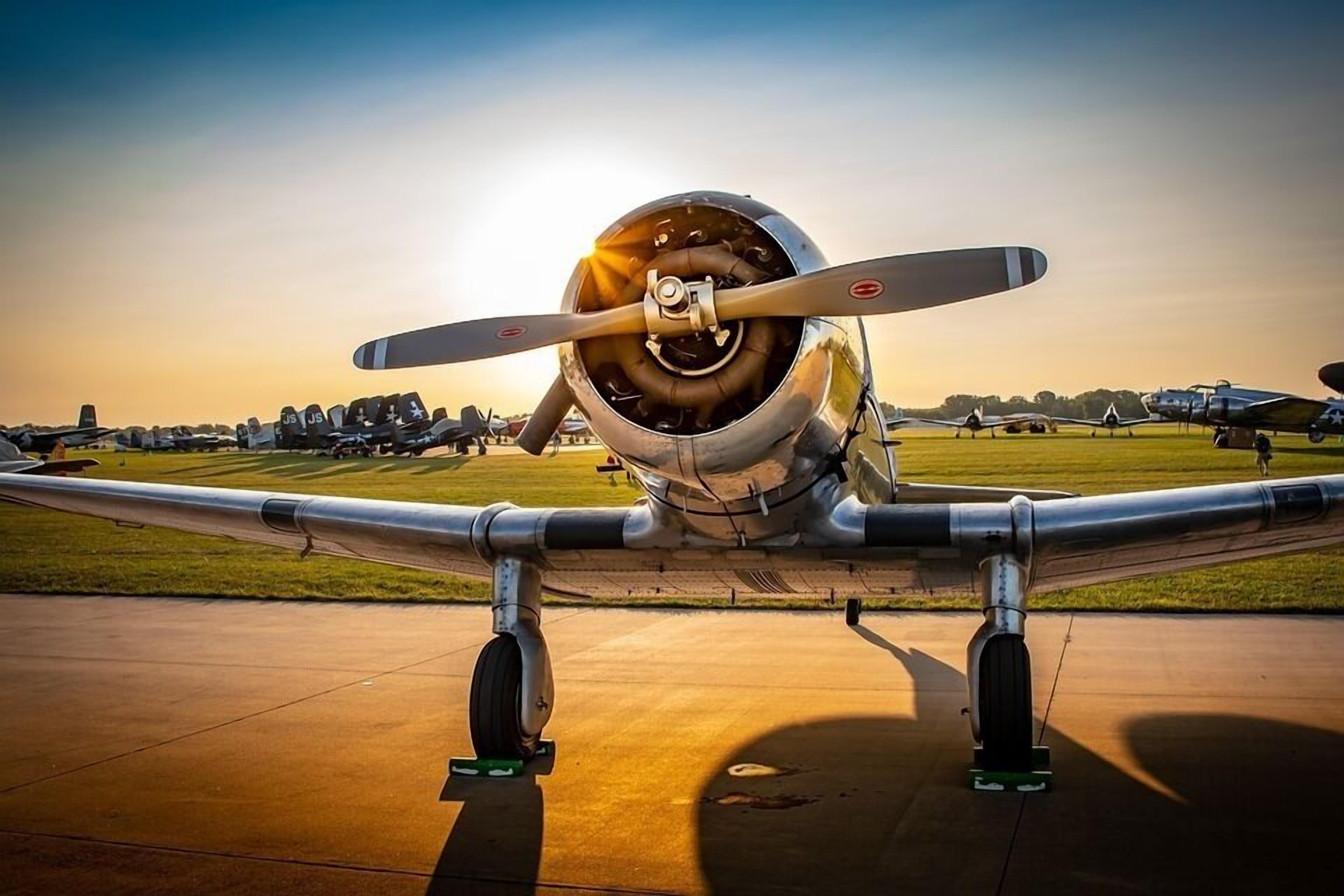 Ein Flugzeug mit Propeller auf der Rollbahn, umgeben von anderen Flugzeugen.