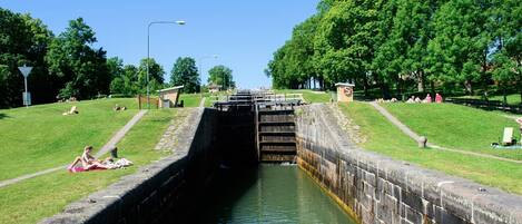 A canal with a lock system, surrounded by grassy areas and trees.