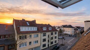 Ein Wohngebiet mit Gebäuden, einer Straße und einem Sonnenuntergang.