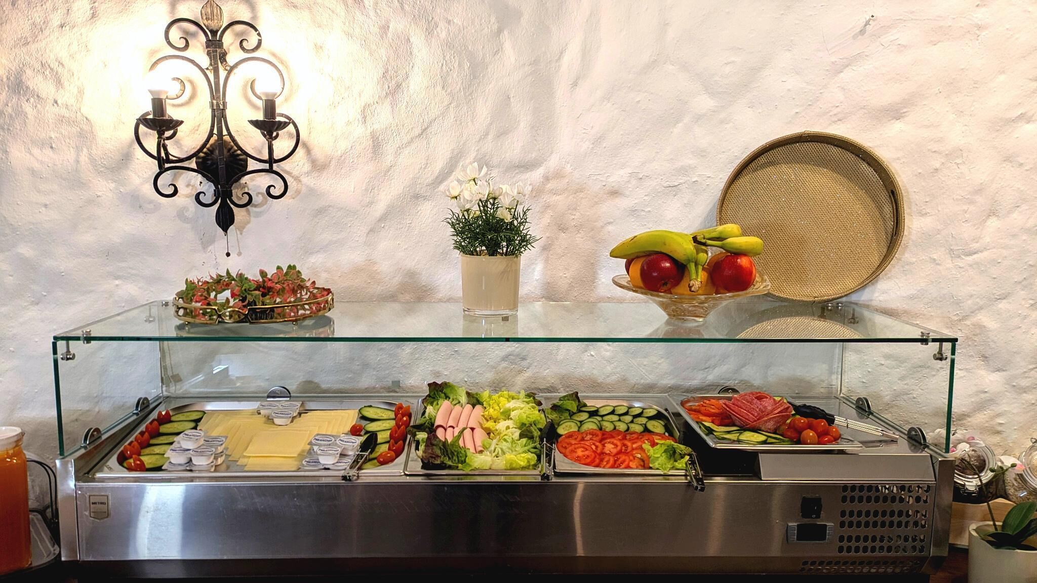 A buffet with various food items, a decorative wall, and a wicker basket.
