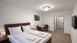 A hotel room with a double bed, two bedside tables with lamps, a small round table with chairs, a television mounted on the wall, and a door leading to another room. - Hotel Hansahof Bremen (Bremen)