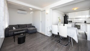 Un appartement moderne comprenant un espace de vie, un coin repas et une cuisine.
