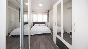Une chambre à coucher avec un grand lit, une armoire et un miroir.