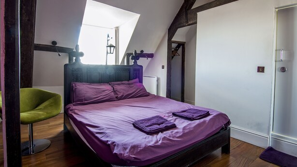 A bedroom with a bed, a chair, a window, and a door. - Safestay York Micklegate (York)