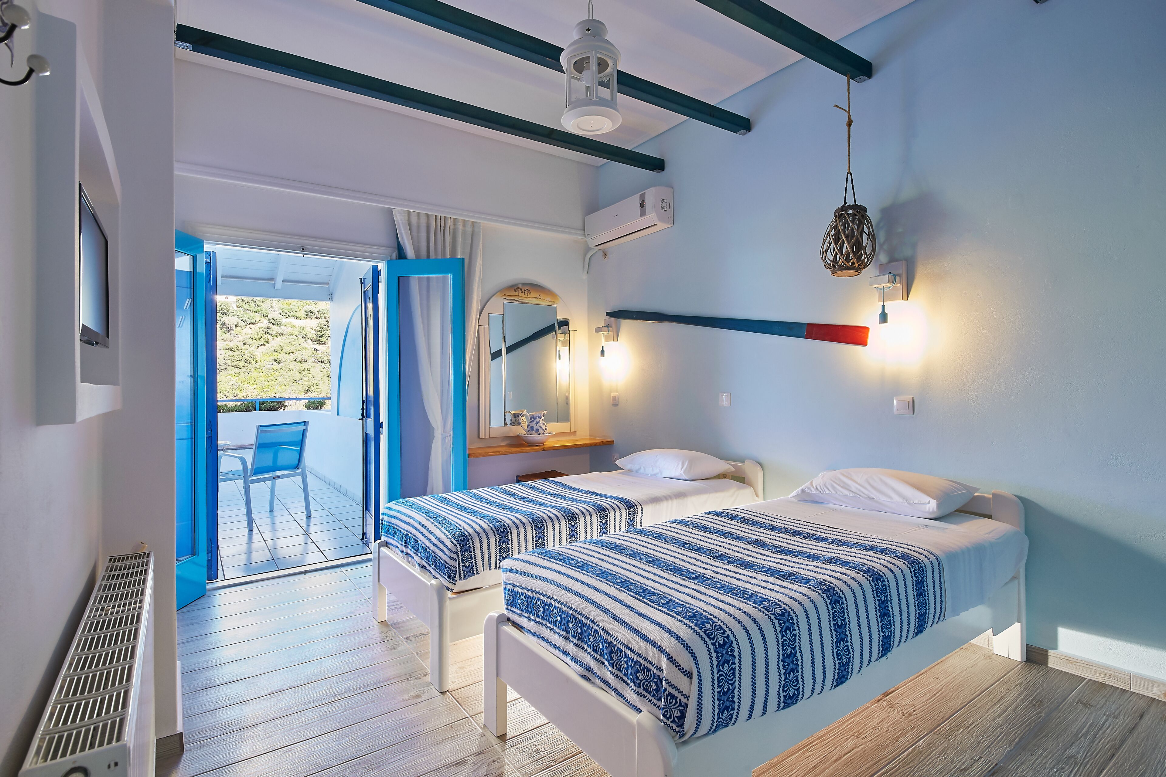 A room with two beds, a bathroom, and a balcony.