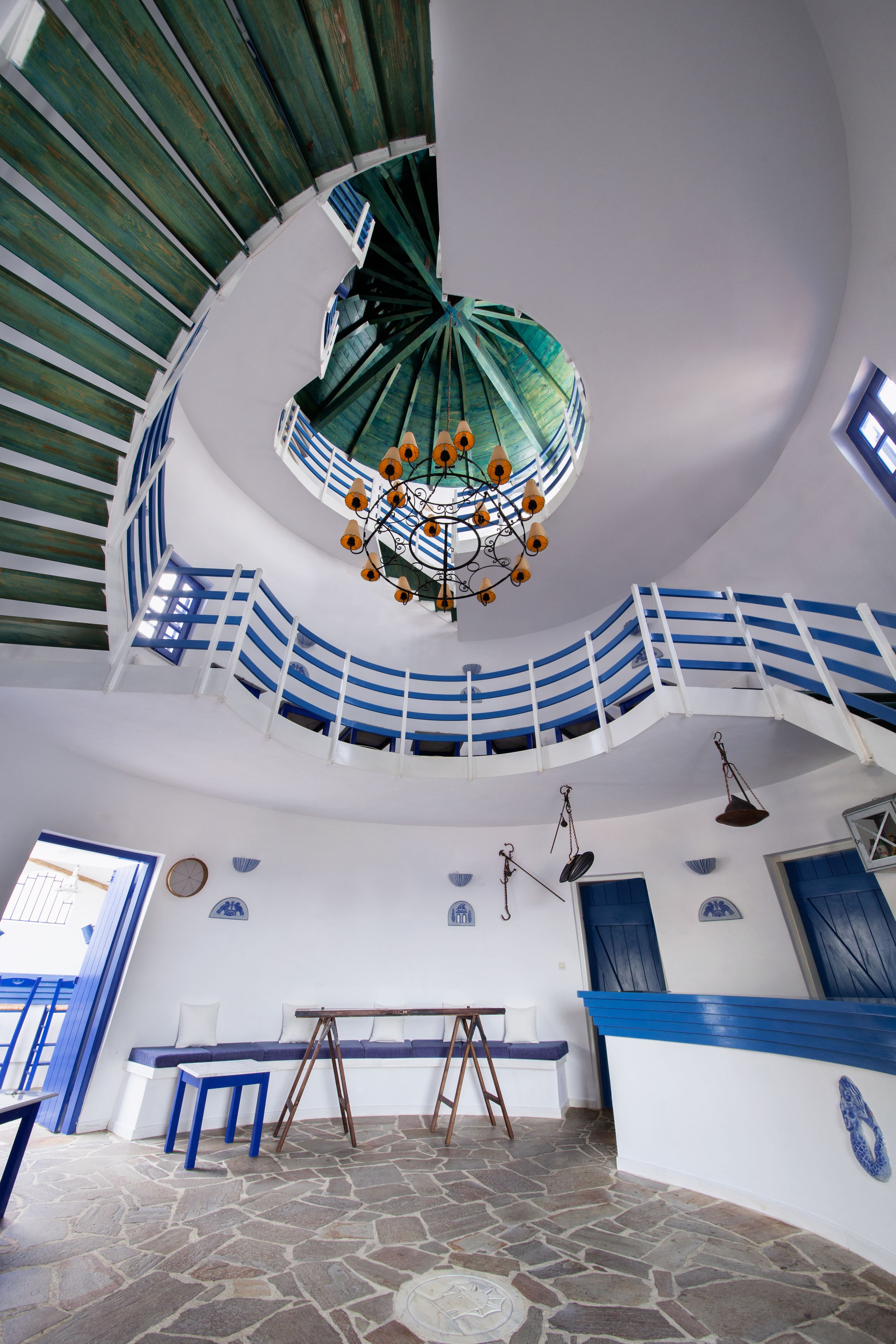 Ein großzügiger Innenraum mit Wendeltreppe, einer Bank und einem Tisch.