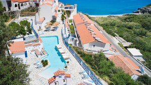 A resort with a swimming pool, beach access, and Mediterranean-style architecture. - Kerame Studios (Ikaria)