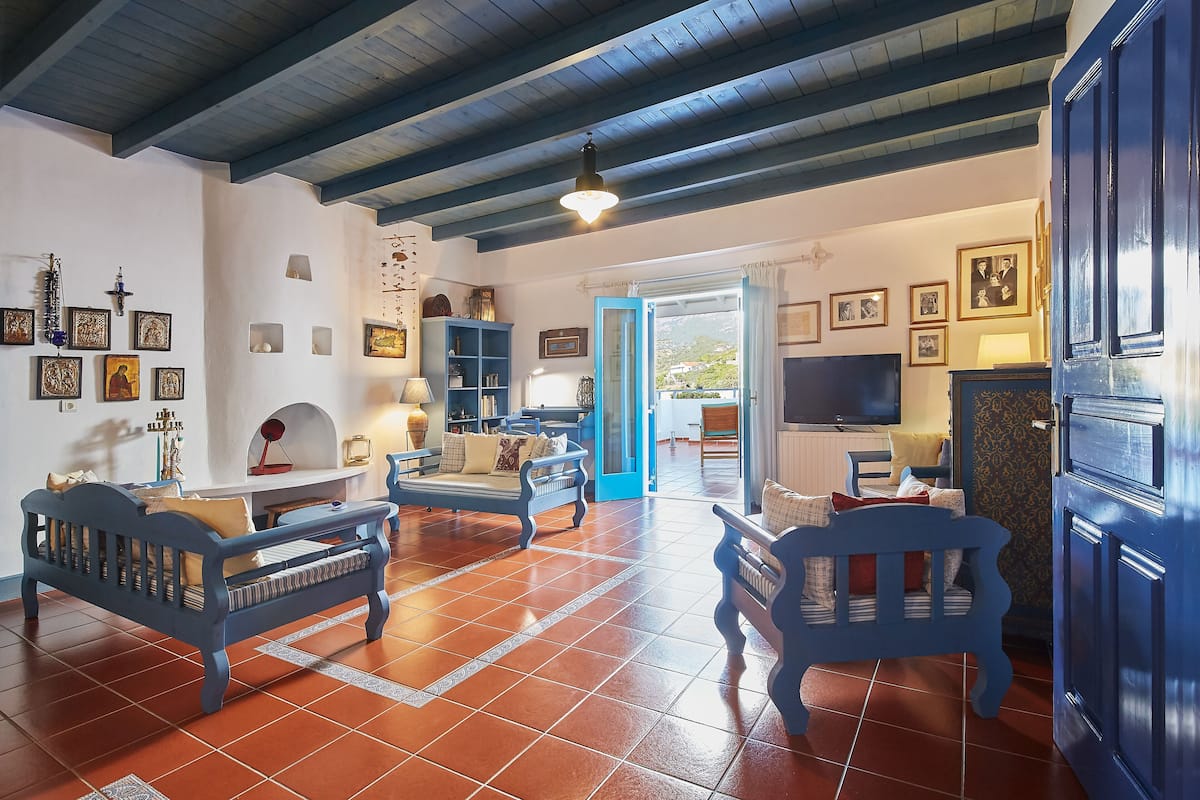 A living room with blue furniture, a TV, and a blue door.