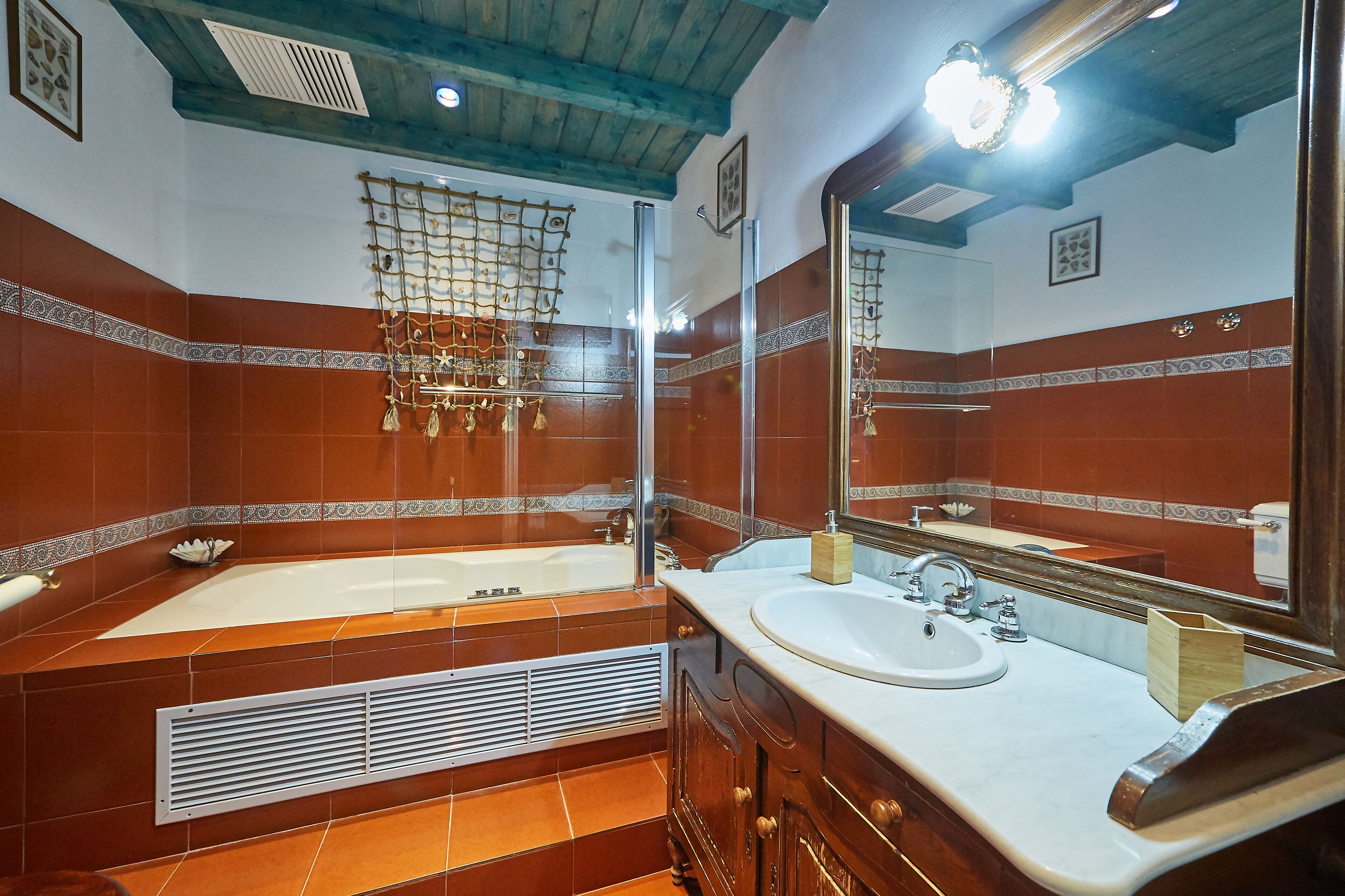 A bathroom with a large bathtub, a sink, and a mirror.