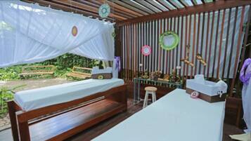 Relax in a serene space with a comfortable bed and a bench, surrounded by a slatted wall and a small stool.