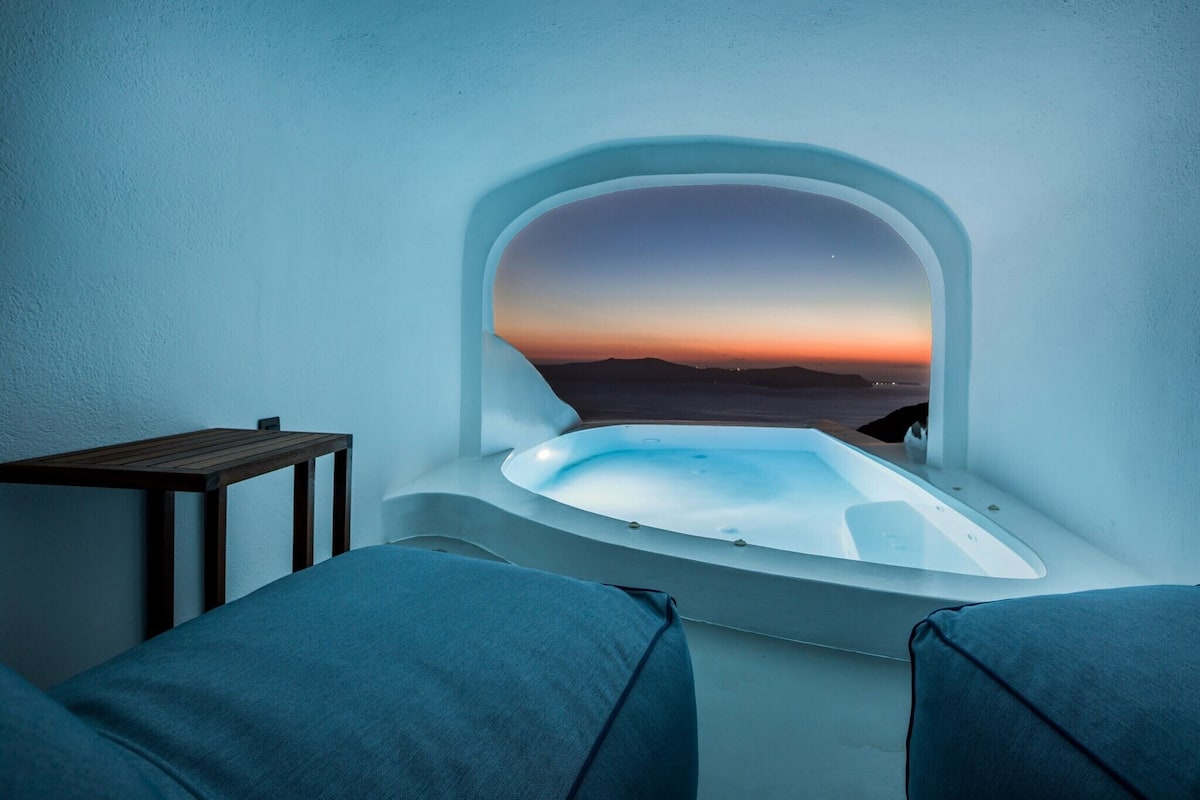 Un espace spa doté d’un bain à remous et offrant une vue sur le coucher de soleil sur l’eau.