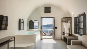 A modern bathroom with a bathtub, a shower area, and a view of the sea. - Sun Rocks Boutique Hotel | Caldera View Suites & Sunset Dining Experience (Santorini)