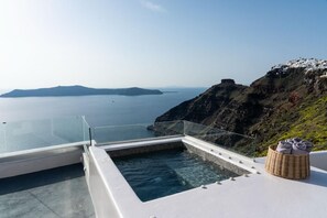 Une piscine à débordement moderne offrant une vue dégagée sur la mer et les îles lointaines.