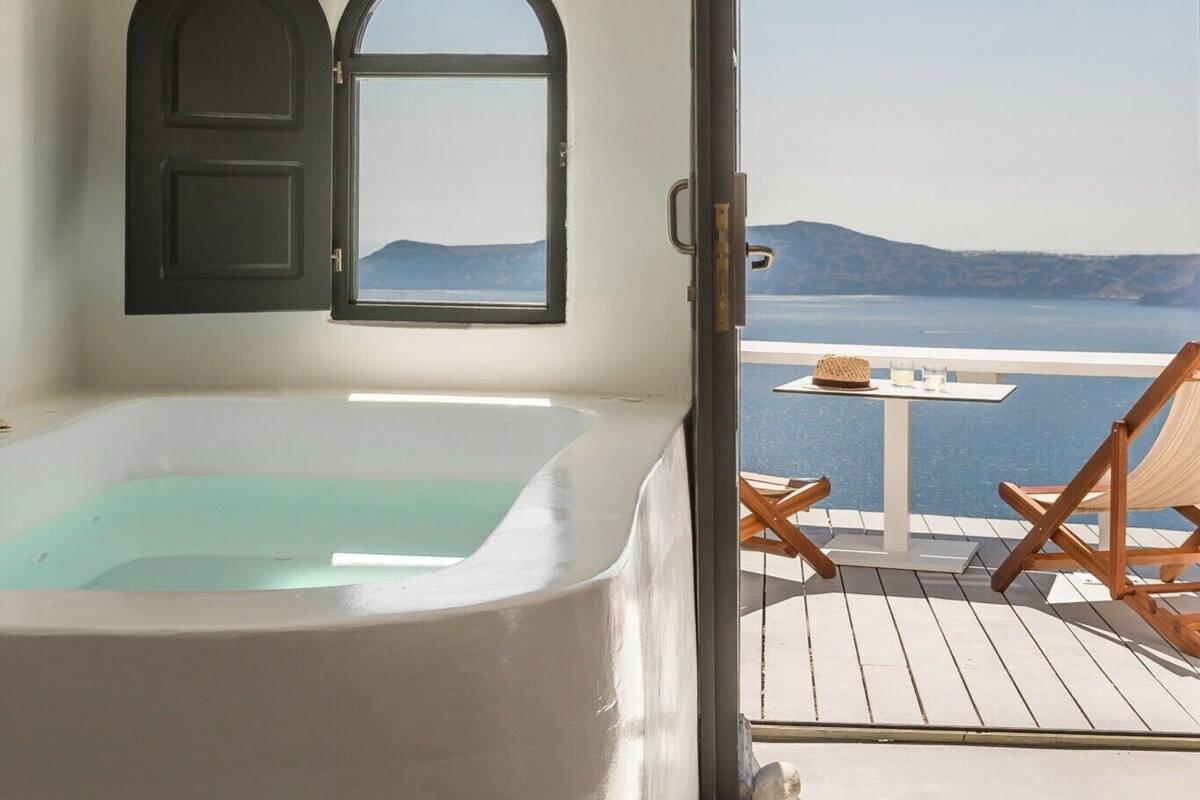 Une chambre avec une baignoire, une fenêtre et une vue sur la mer.