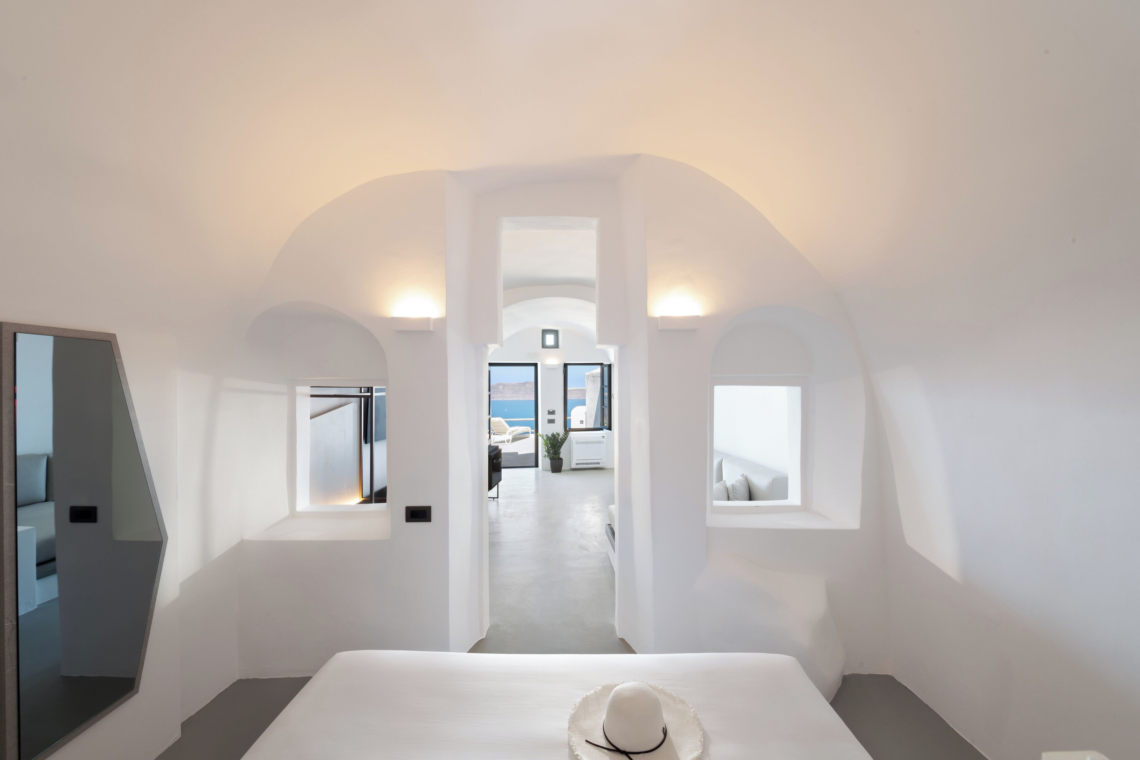 Ein modernes Hotelzimmer mit einem großen Bett, Meerblick und minimalistischem Design.